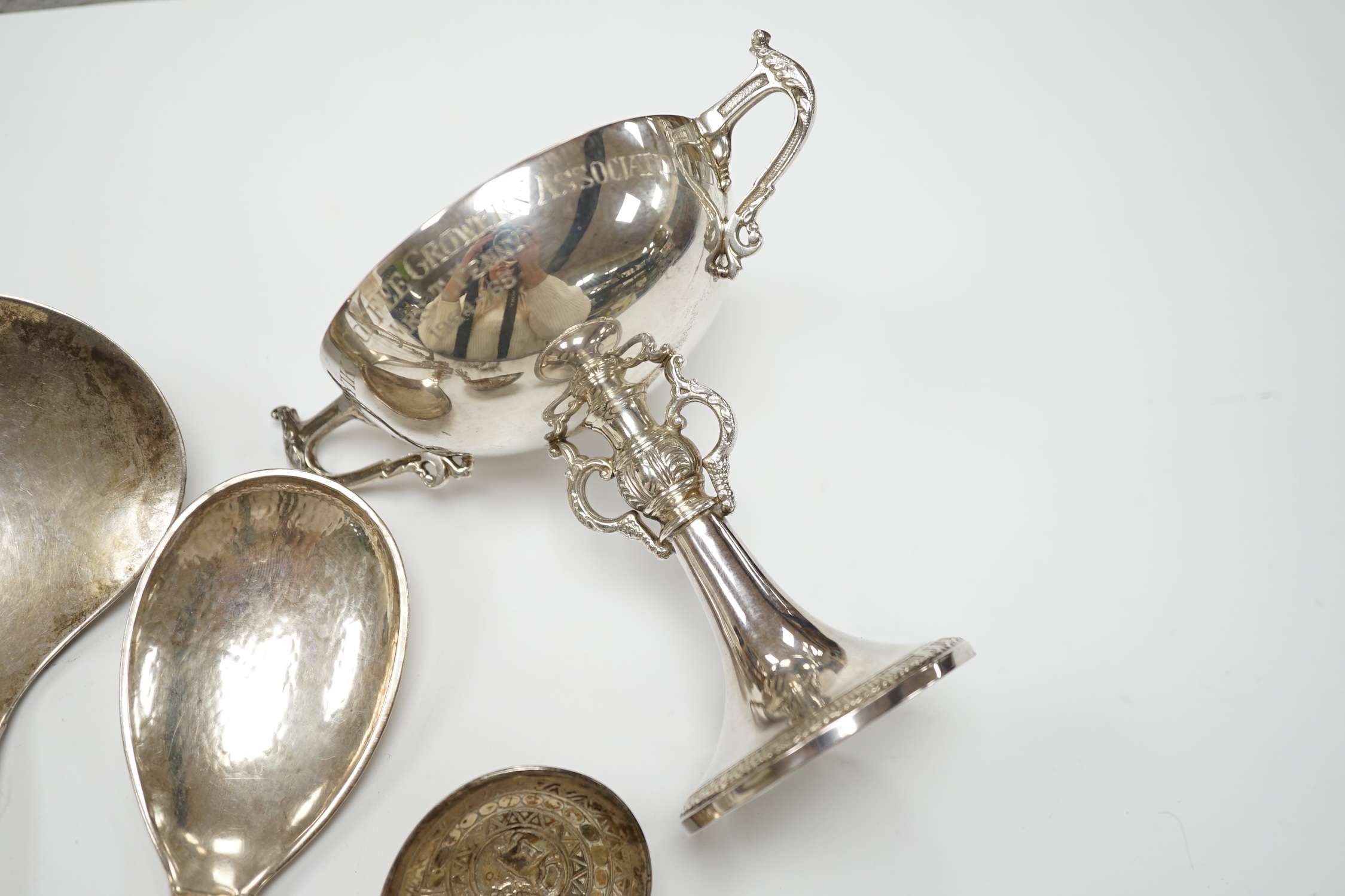 Five assorted early to mid 20th century Danish 830S spoons, largest 21.1cm, together with an Elizabeth II silver two handled presentation trophy cup with engraved inscription relating to the 'Tanganyika Coffee Growers As